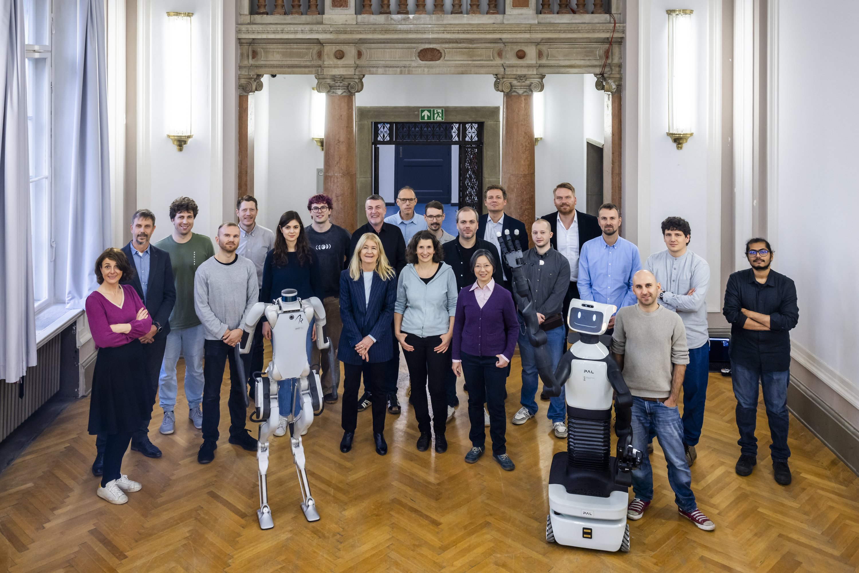 Group photo of the participants of the research meeting with two robots